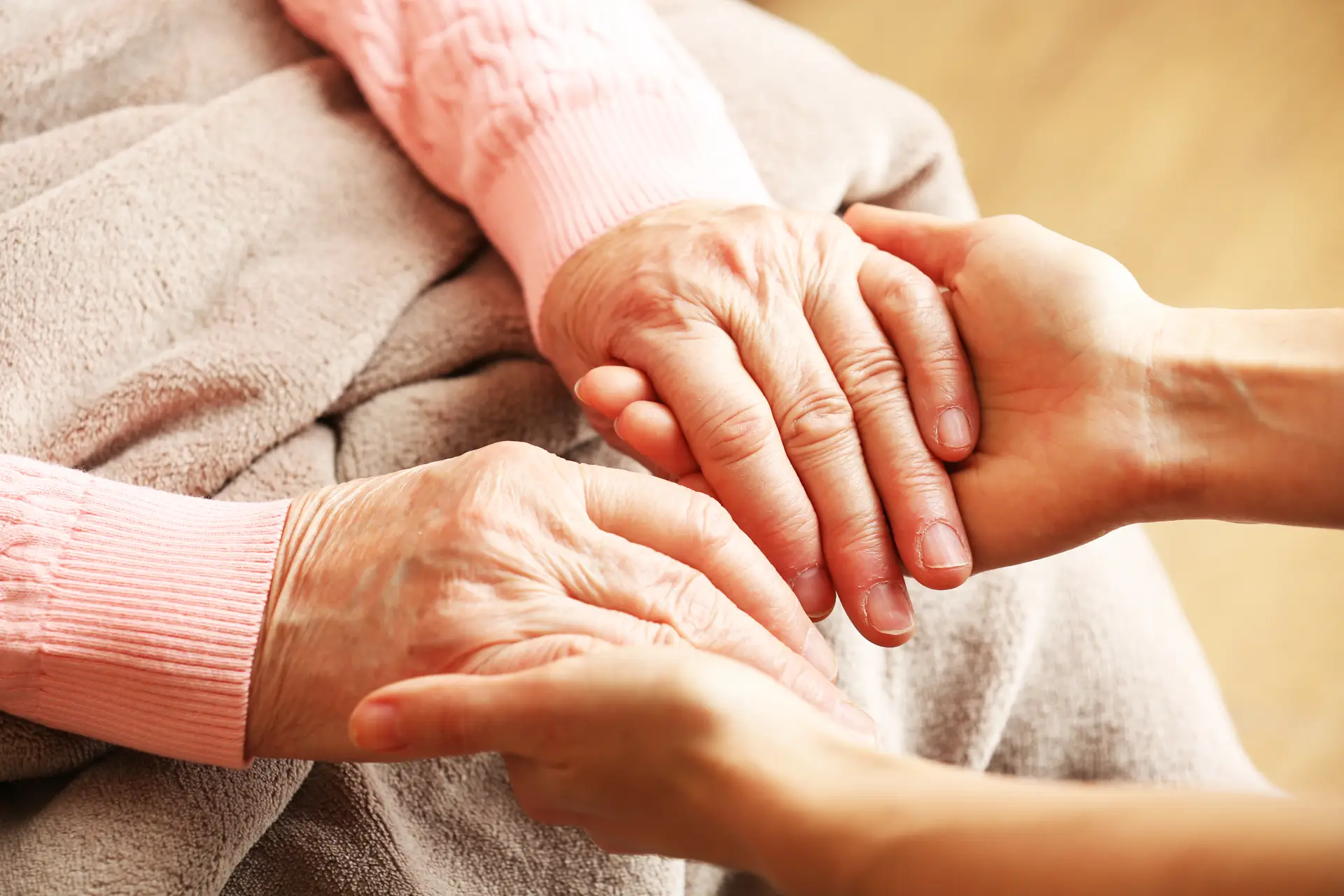 Caregiver and Senior holding hands. Represents In-Home Personal Care, Companion Care and Nursing Services